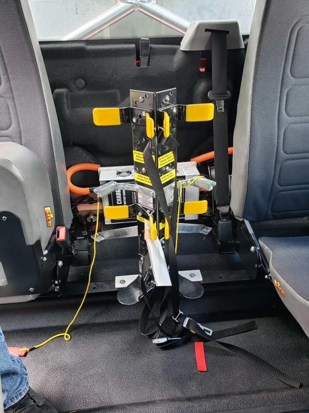 Exterior view of small fire truck showing cab, body compartments, and wheel/tire area.