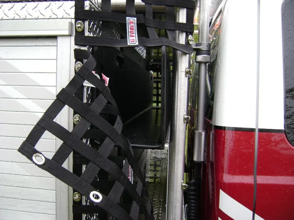 Exterior view of small fire truck showing cab, body compartments, and wheel/tire area.