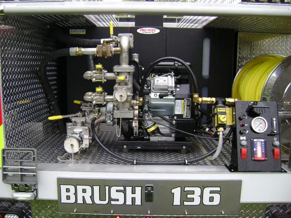 Exterior view of small fire truck showing cab, body compartments, and wheel/tire area.