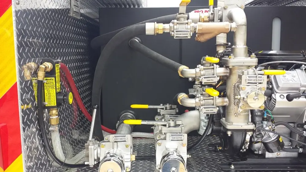 Exterior view of small fire truck showing cab, body compartments, and wheel/tire area.