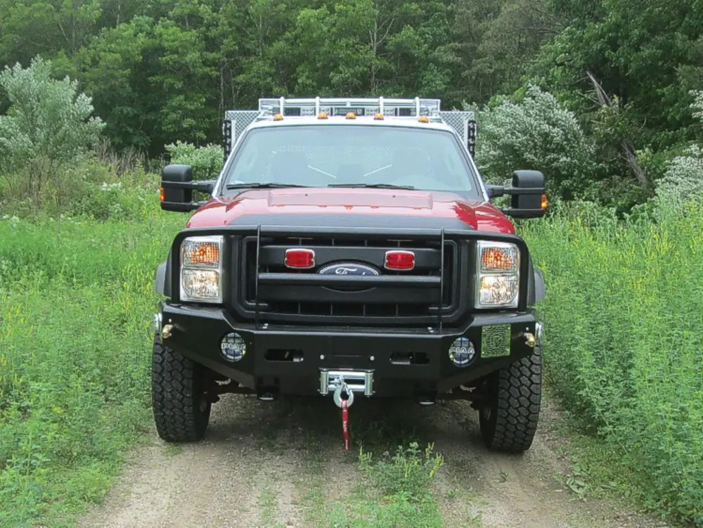 Exterior view of small fire truck showing cab, body compartments, and wheel/tire area.