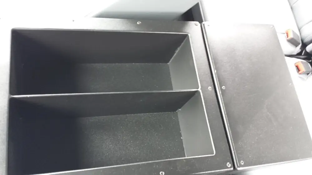 Exterior view of small fire truck showing cab, body compartments, and wheel/tire area.