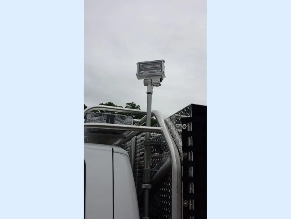 Exterior view of small fire truck showing cab, body compartments, and wheel/tire area.