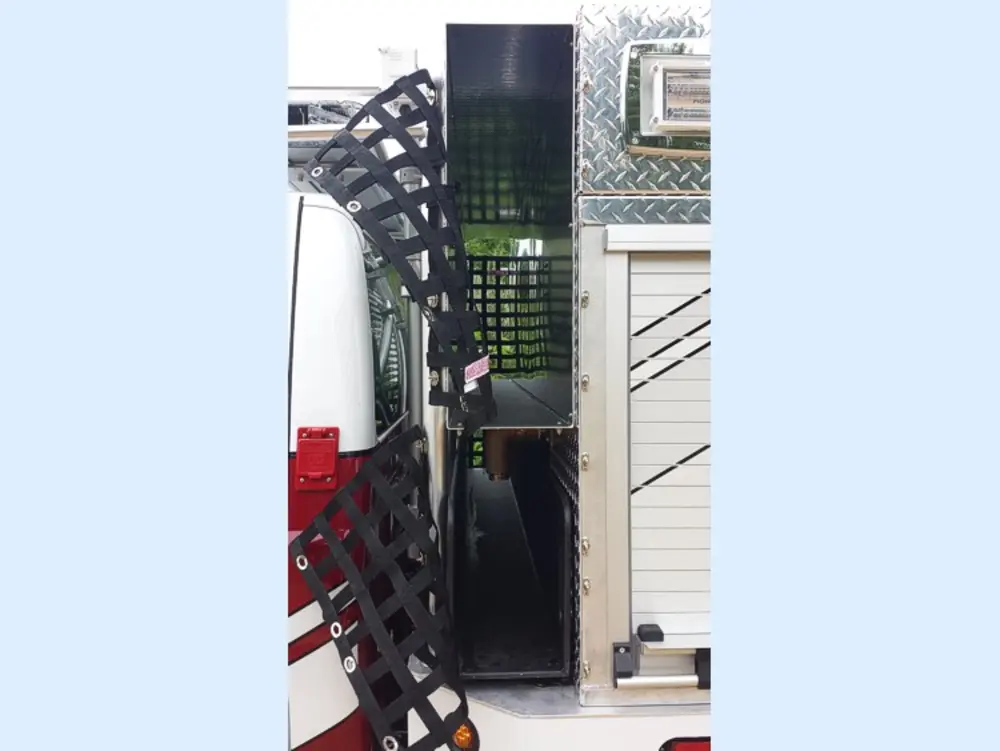 Exterior view of small fire truck showing cab, body compartments, and wheel/tire area.