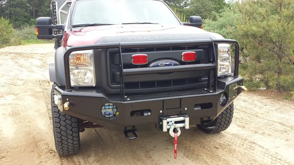 Exterior view of small fire truck showing cab, body compartments, and wheel/tire area.