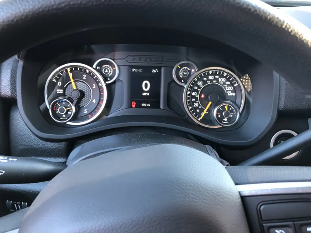 Exterior view of small fire truck showing cab, body compartments, and wheel/tire area.