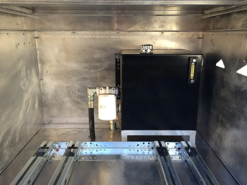 Exterior view of small fire truck showing cab, body compartments, and wheel/tire area.