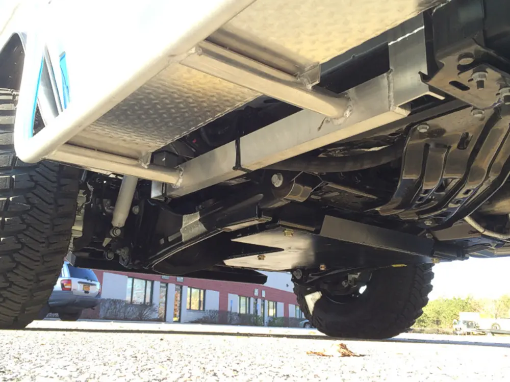 Exterior view of small fire truck showing cab, body compartments, and wheel/tire area.