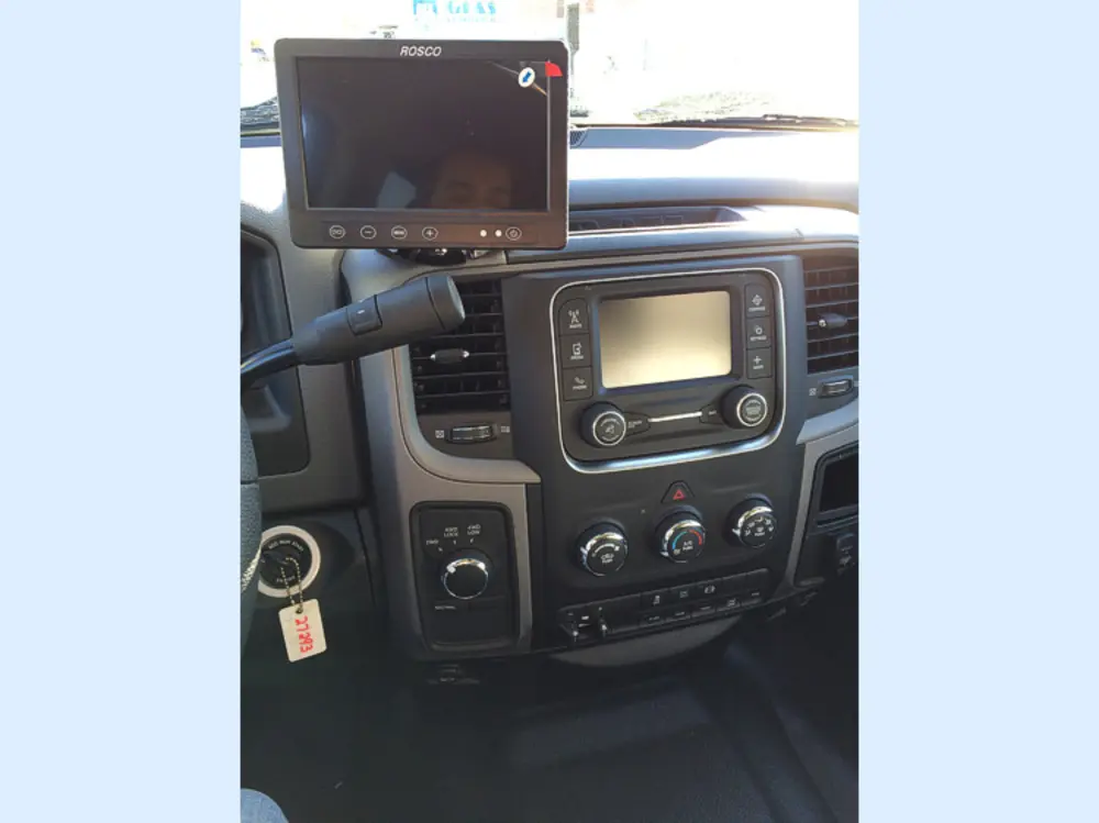 Exterior view of small fire truck showing cab, body compartments, and wheel/tire area.