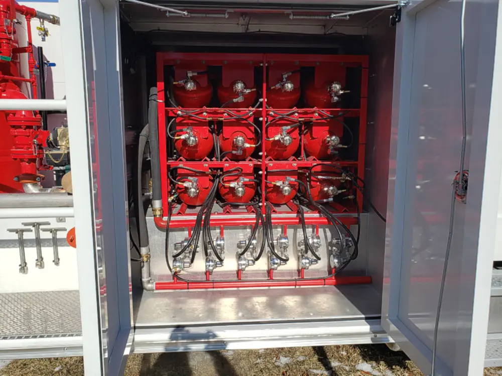 Exterior view of small fire truck showing cab, body compartments, and wheel/tire area.