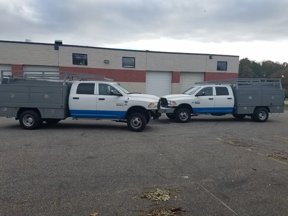 Exterior view of small fire truck showing cab, body compartments, and wheel/tire area.
