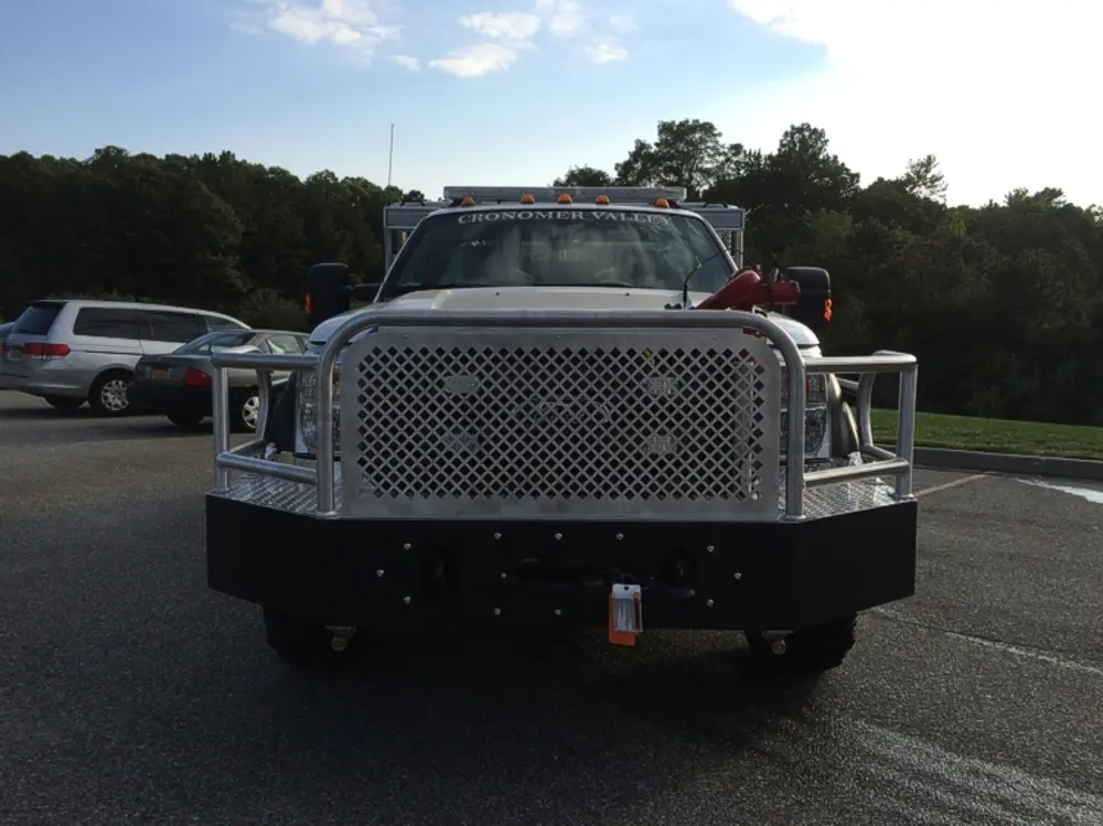 Exterior view of small fire truck showing cab, body compartments, and wheel/tire area.