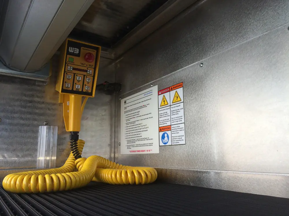 Exterior view of small fire truck showing cab, body compartments, and wheel/tire area.