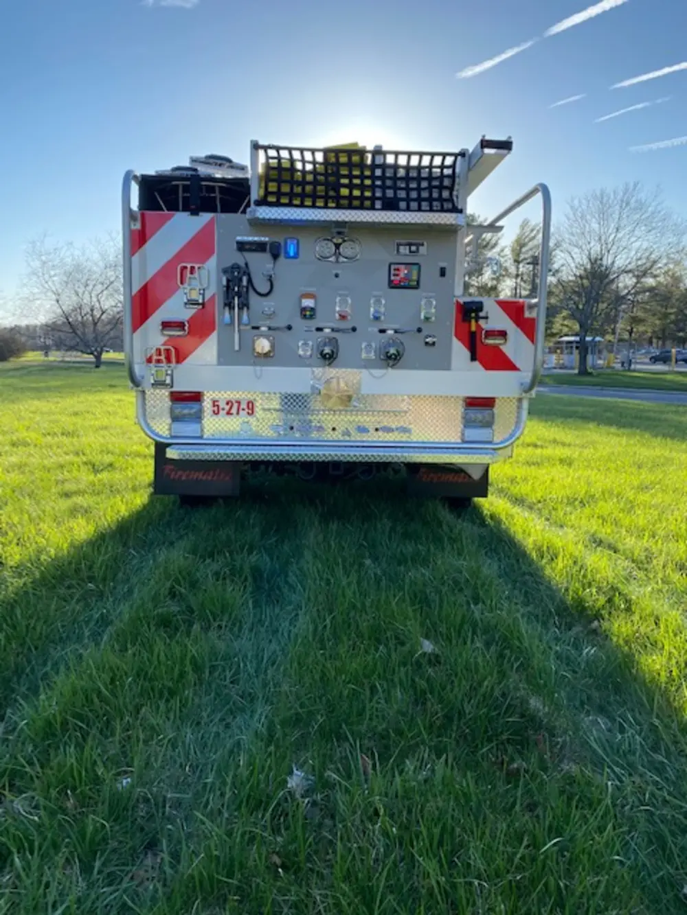 Exterior view of small fire truck showing cab, body compartments, and wheel/tire area.