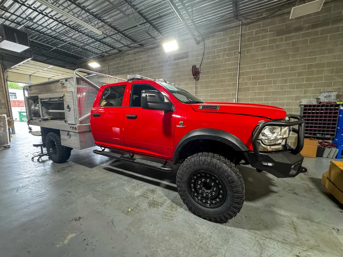 Front-right side view showing the cab profile, front wheel area, and aluminum body compartments.