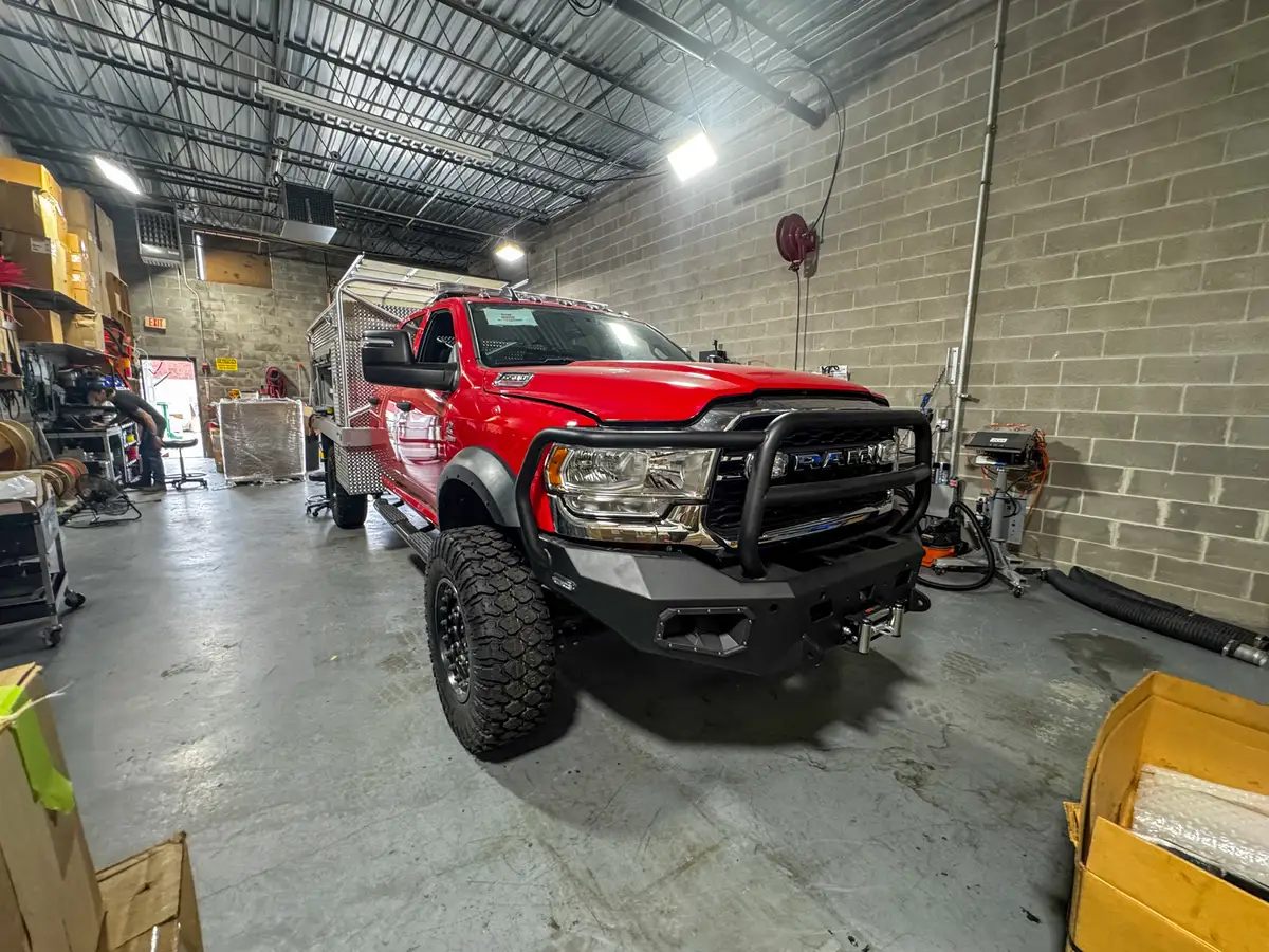 Low front-left view showing the grille guard, bumper, front tire, and side body section.
