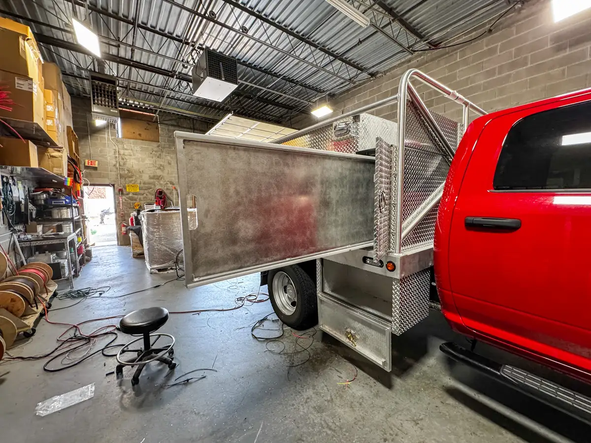 Left-side view of the long compartment door swung open, exposing the full side storage opening.