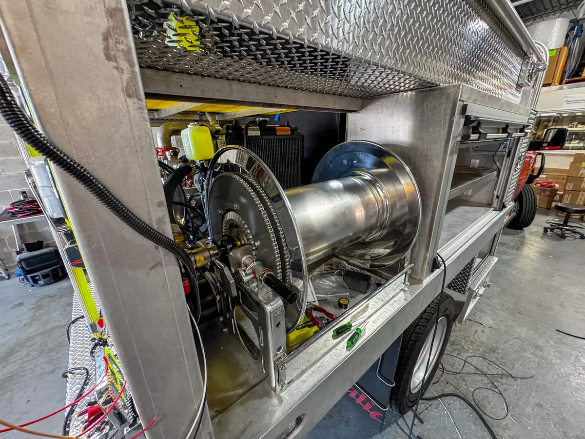 Close-up of the rear-side hose reel assembly inside the open side bay.