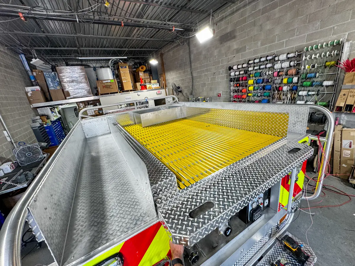 Top deck view showing the yellow grated hosebed area and aluminum side channels.