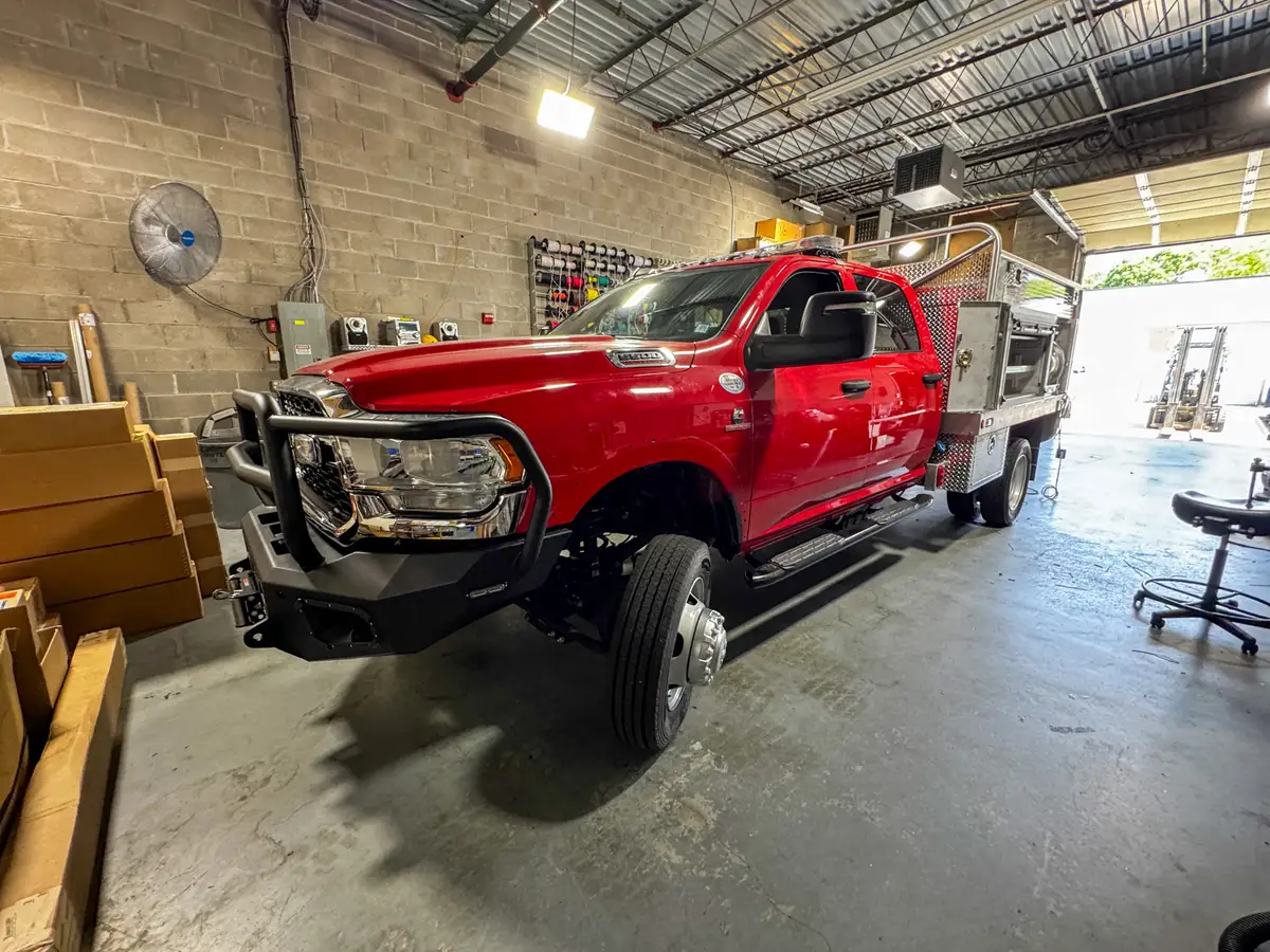 Front-left exterior view showing the cab, turned front wheel area, and open side compartment door.