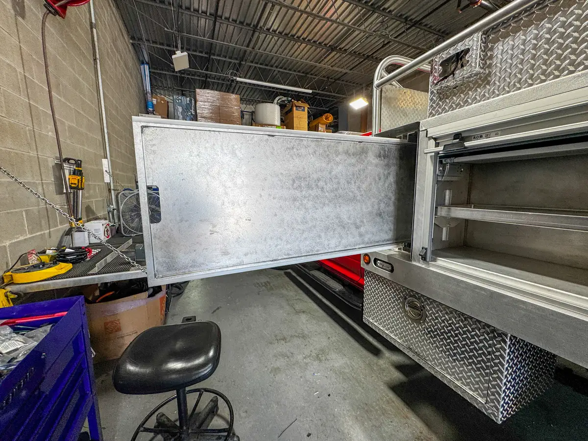 Side compartment door interior view with the long door open next to the shelf compartment.
