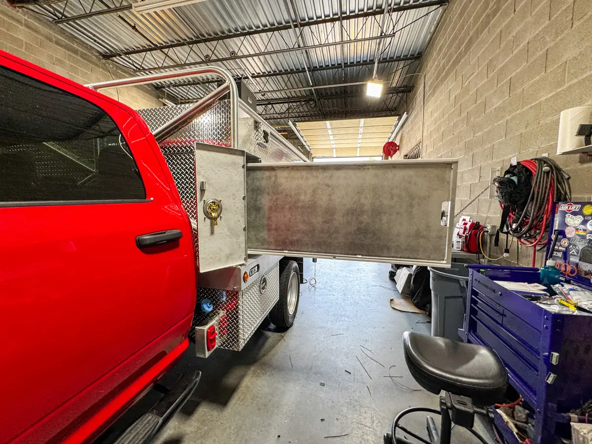 Side view near the cab showing a small service door open beside the main shelf compartment.
