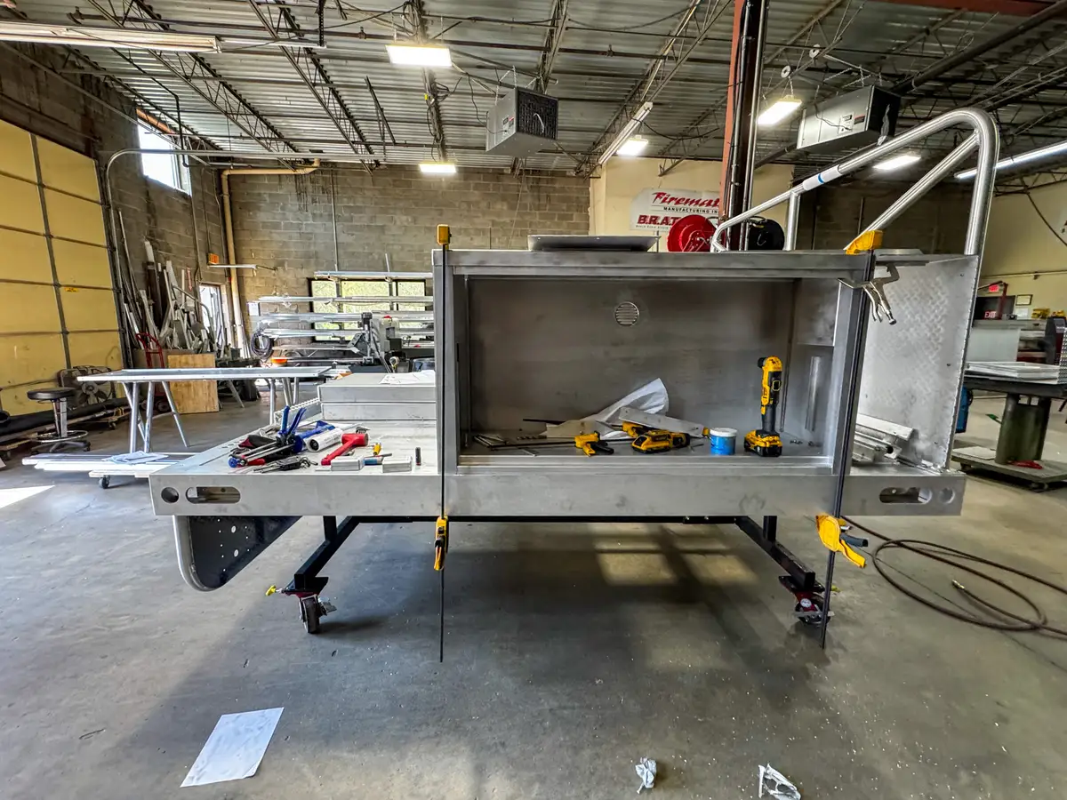 Side view of the body module on stands showing an open large compartment and interior tool space.