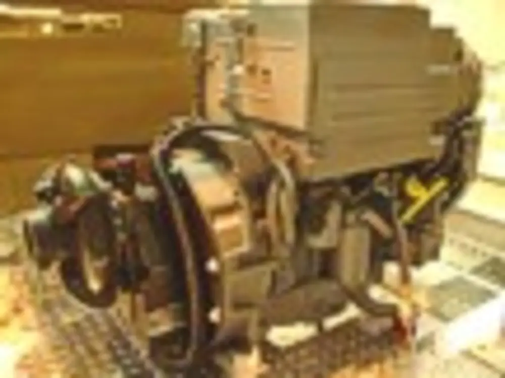 Exterior view of small fire truck showing cab, body compartments, and wheel/tire area.