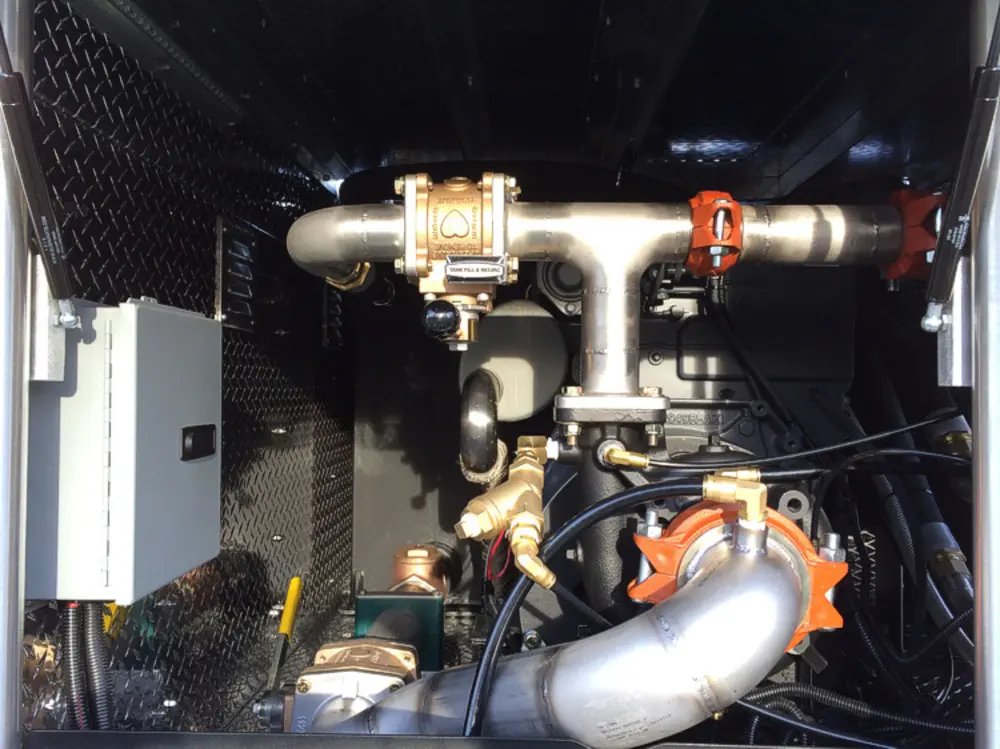 Exterior view of small fire truck showing cab, body compartments, and wheel/tire area.