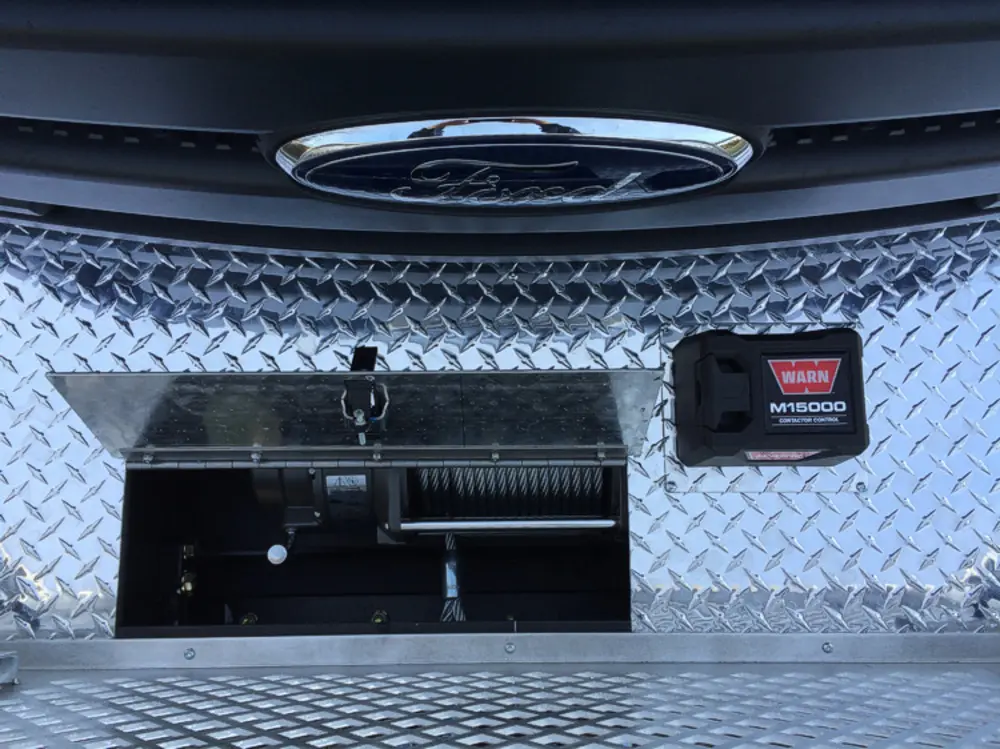 Exterior view of small fire truck showing cab, body compartments, and wheel/tire area.