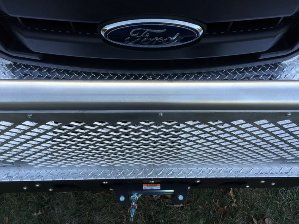 Exterior view of small fire truck showing cab, body compartments, and wheel/tire area.
