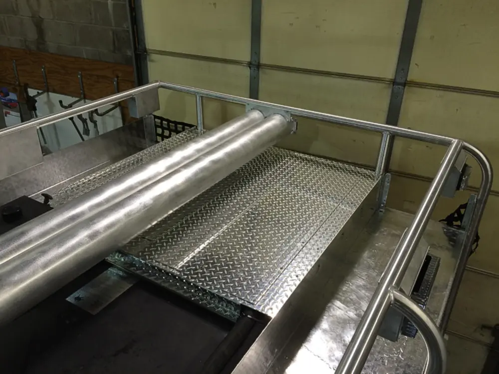 Exterior view of small fire truck showing cab, body compartments, and wheel/tire area.