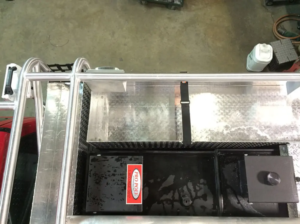 Exterior view of small fire truck showing cab, body compartments, and wheel/tire area.