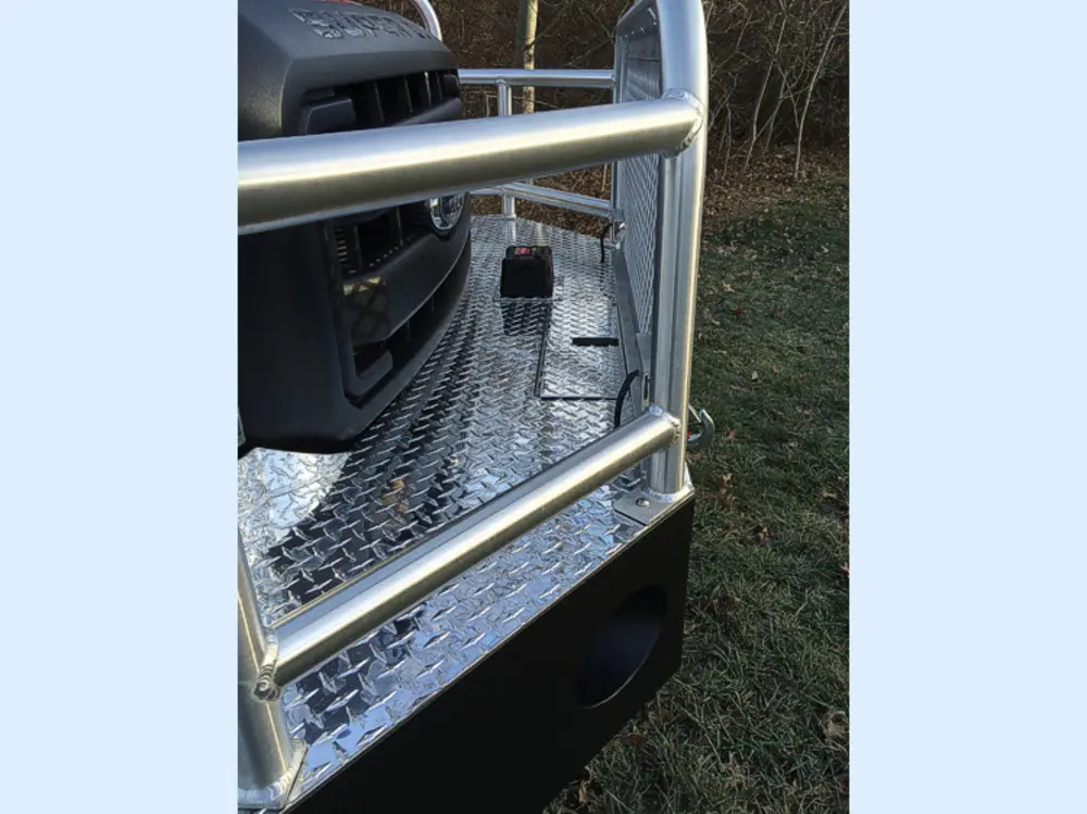 Exterior view of small fire truck showing cab, body compartments, and wheel/tire area.