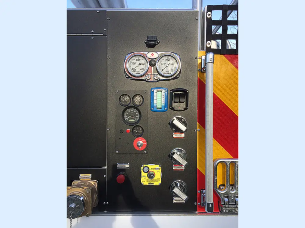 Exterior view of small fire truck showing cab, body compartments, and wheel/tire area.