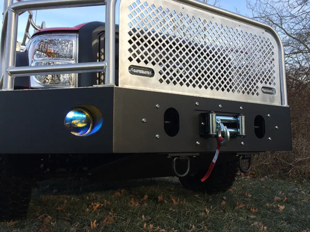 Exterior view of small fire truck showing cab, body compartments, and wheel/tire area.