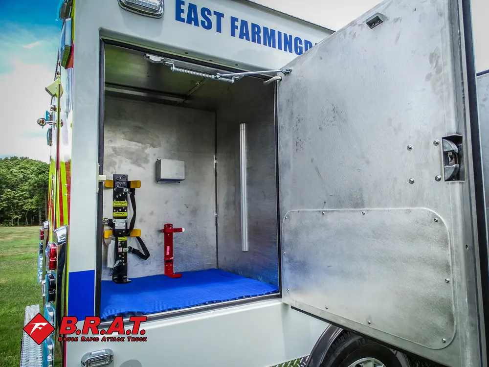 Open side compartment with mounted tools and blue floor.