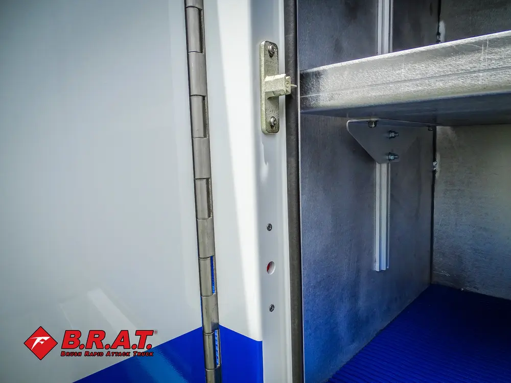 Compartment corner with blue floor and side shelf bracket.