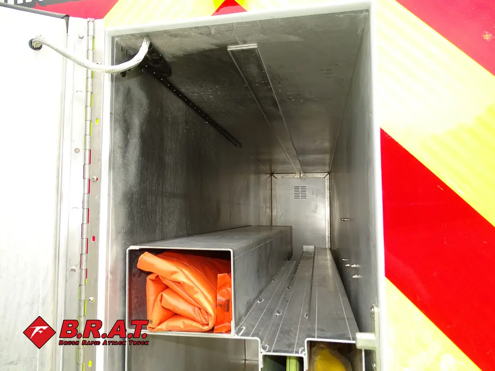 Inside narrow rear compartment with folded orange hose.