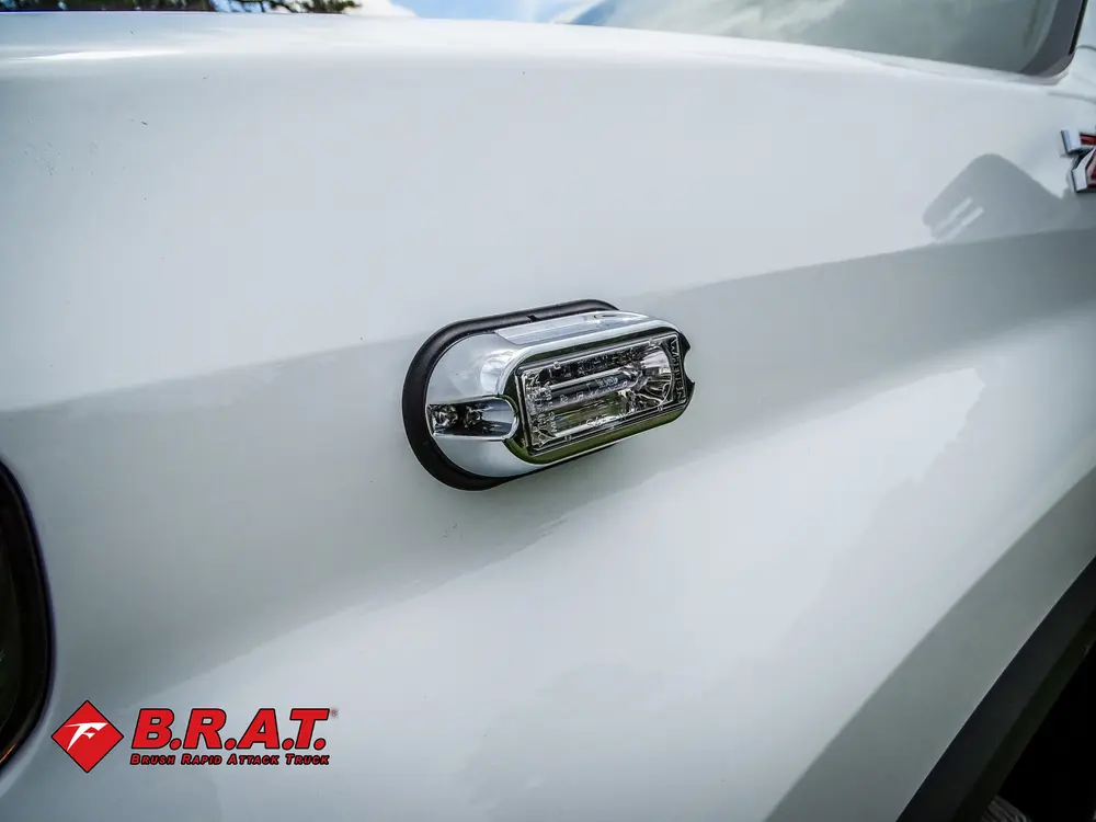 Side marker light close-up on white body panel.