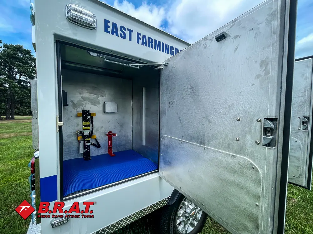 Open side compartment with mounted tools on blue floor.