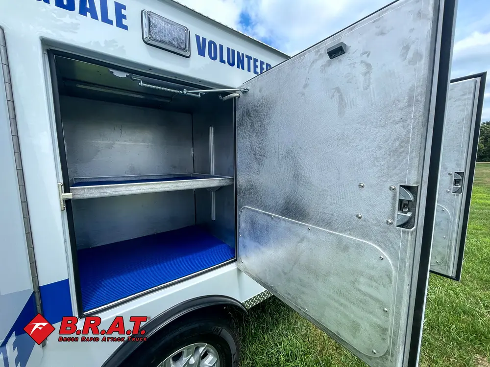 Open side shelf compartment with stainless interior and blue floor.