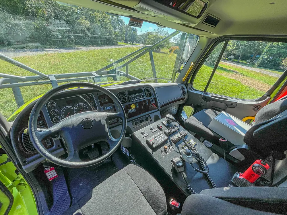 Driver area from elevated angle showing steering wheel and controls.