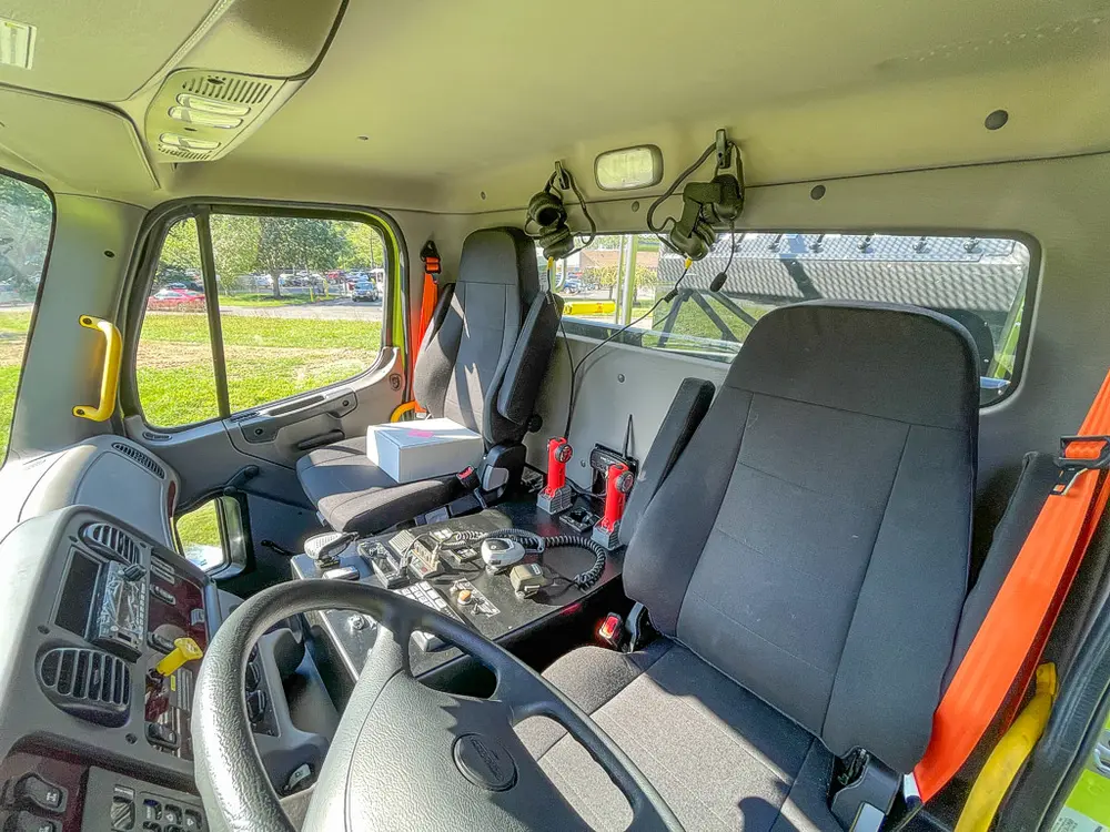 Cab interior with center console, radios, and front seats.