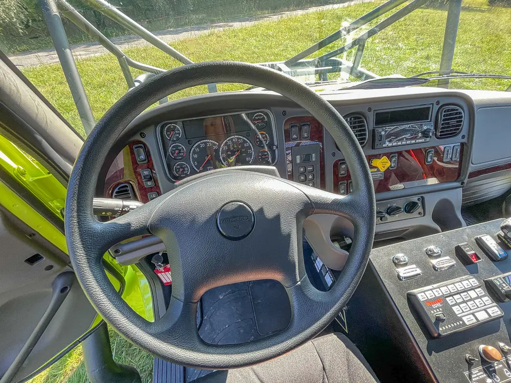Steering wheel and driver dashboard from left seat.