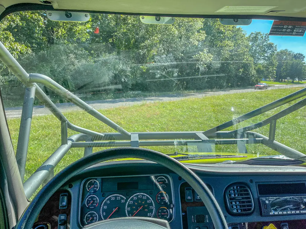 Driver gauge cluster and windshield view over steering wheel.