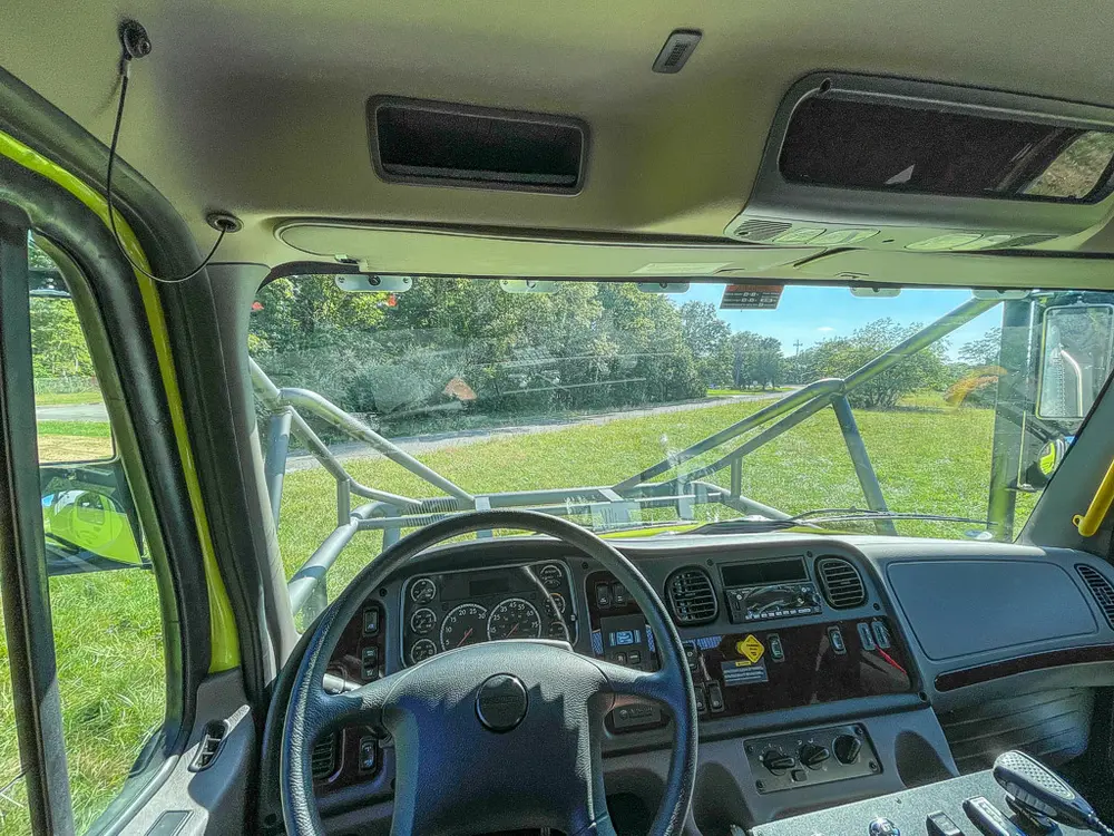 Wide dashboard view from center showing windshield and controls.