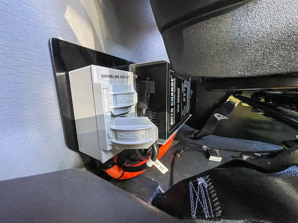 Under-dash area with mounted electronic modules and wiring.