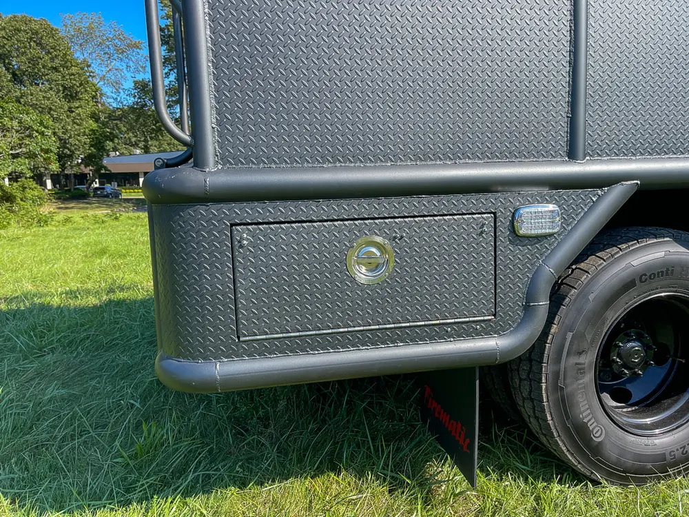 Closed rear side compartment near back wheel and mudflap.