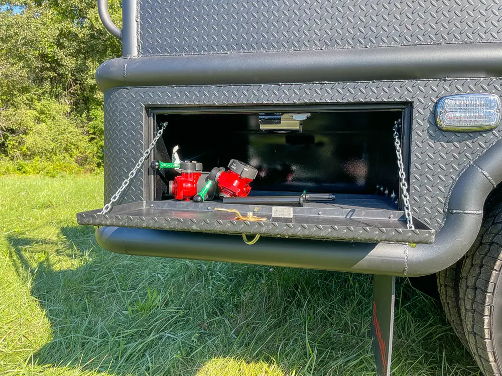 Open rear side compartment containing small red fittings.